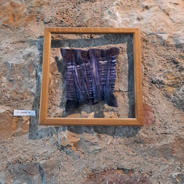 Tissage violet et bleu présenté dans un cadre en bois