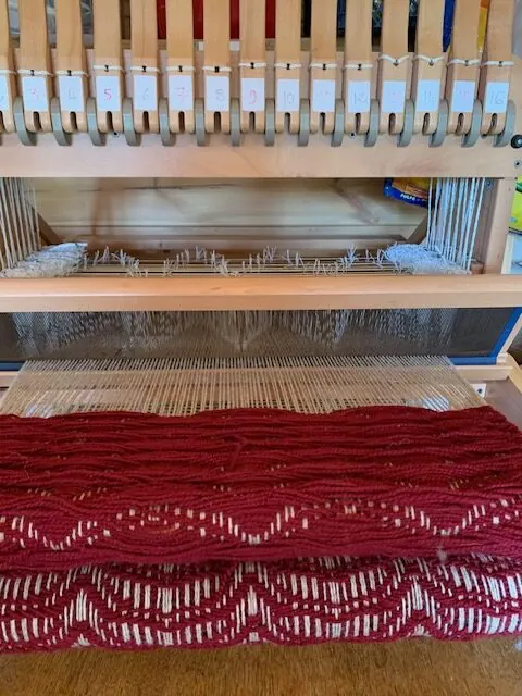 Tissage rouge en cours sur un métier à tisser à 16 cadres
